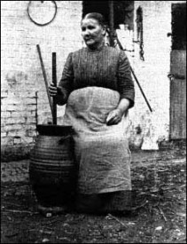 Eifeler Bäuerin beim Buttern in einer Langerweher Schilderbaare.